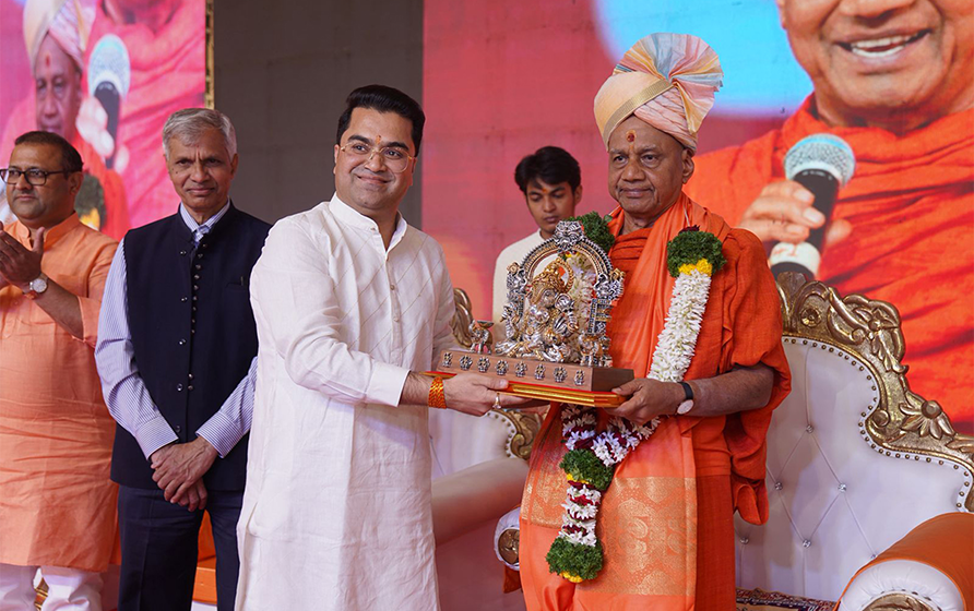 Abhay Bhutada presenting a Ganesh idol to Swami Govind Dev Giri Maharaj during the Gita Jayanti Mahotsav in Alandi